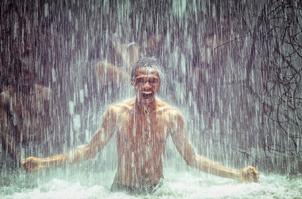 Hombre bañandose en una cascada